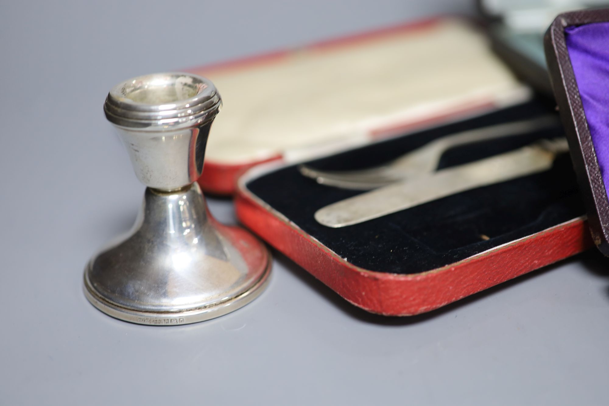 A pair of silver dwarf candlesticks and various cased silver items,